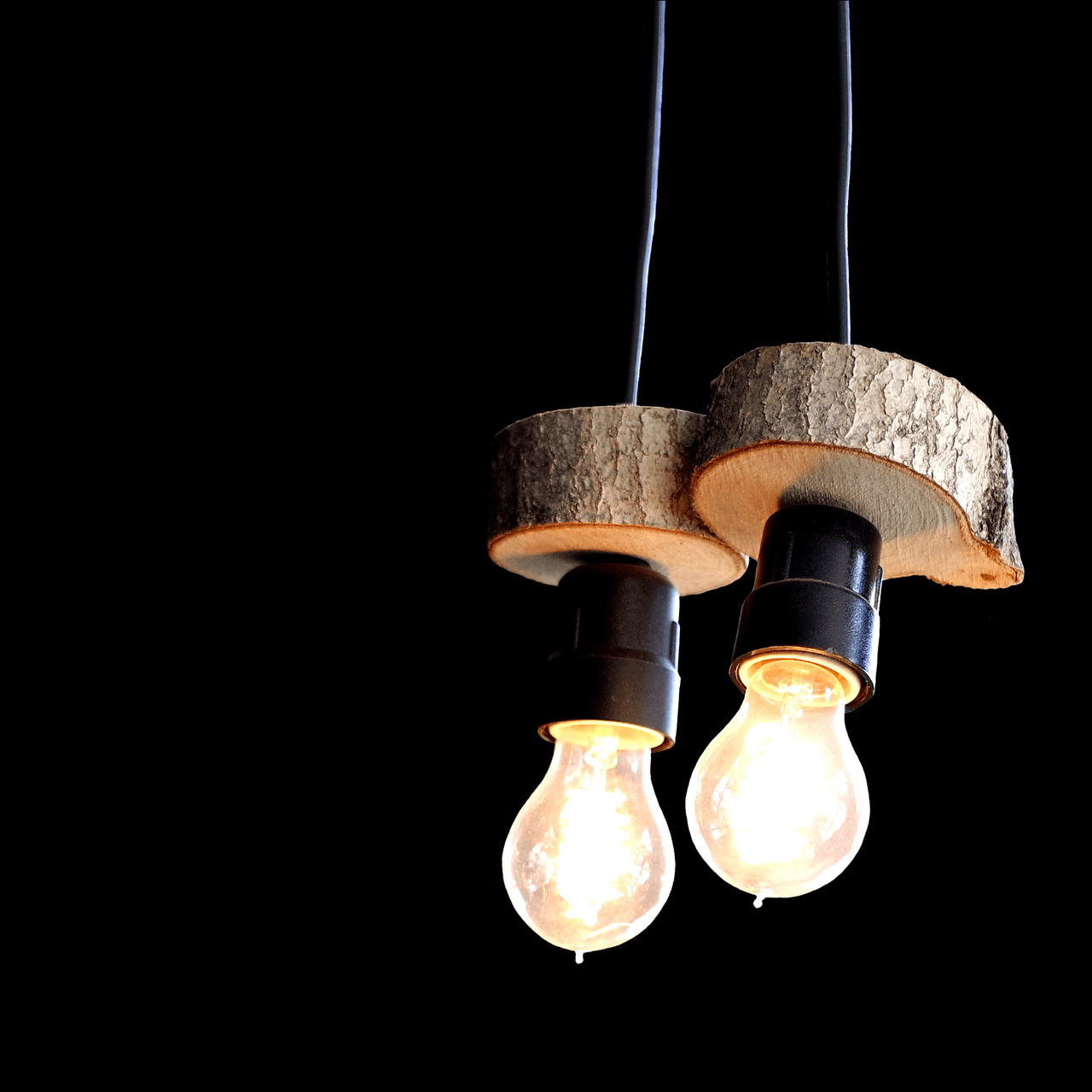 L'image montre une lampe suspendue faîte dans des rondins de bois