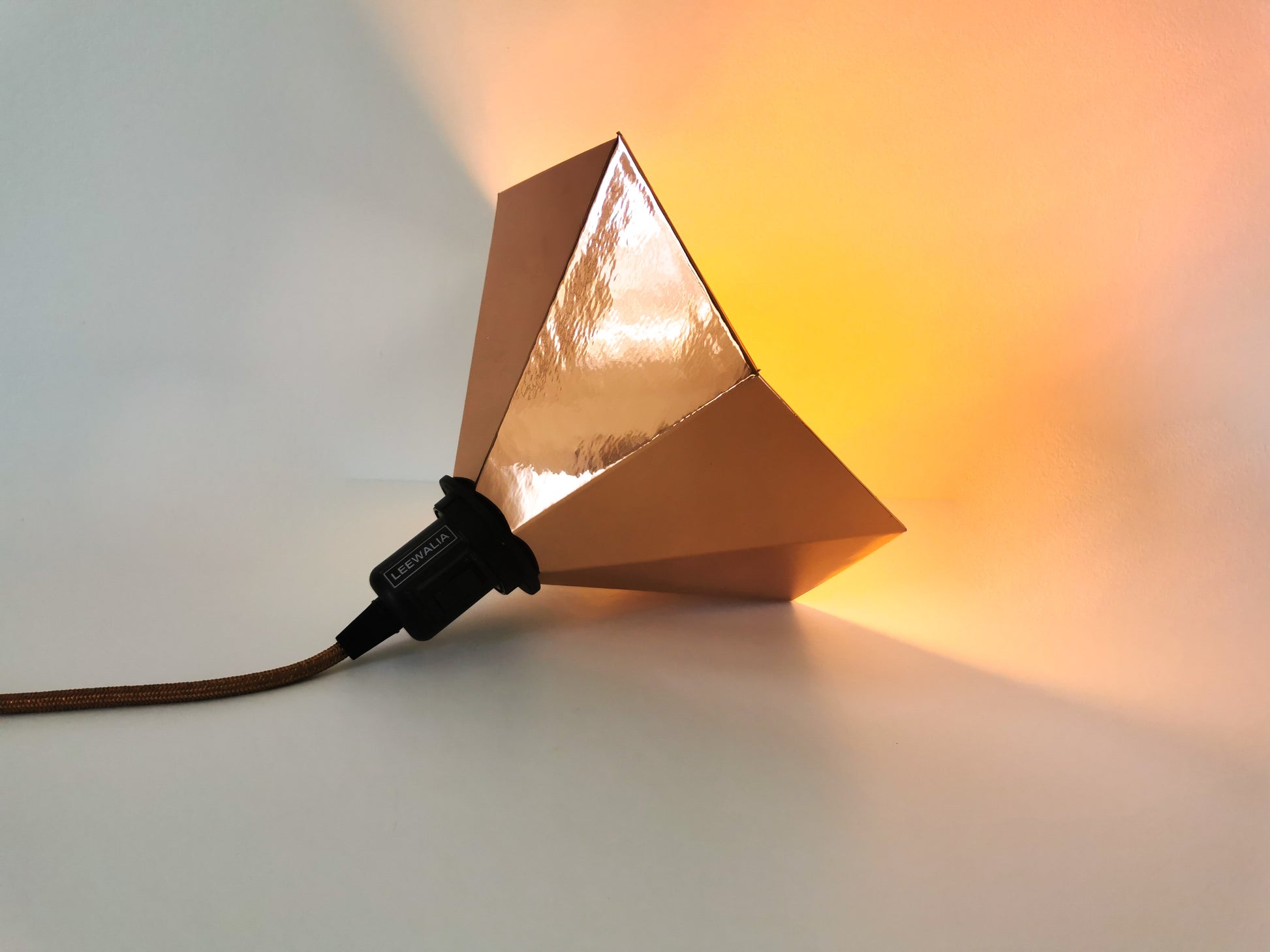 Une Lampe Baladeuse dessiné comme un gramophone de couleur cuivre.