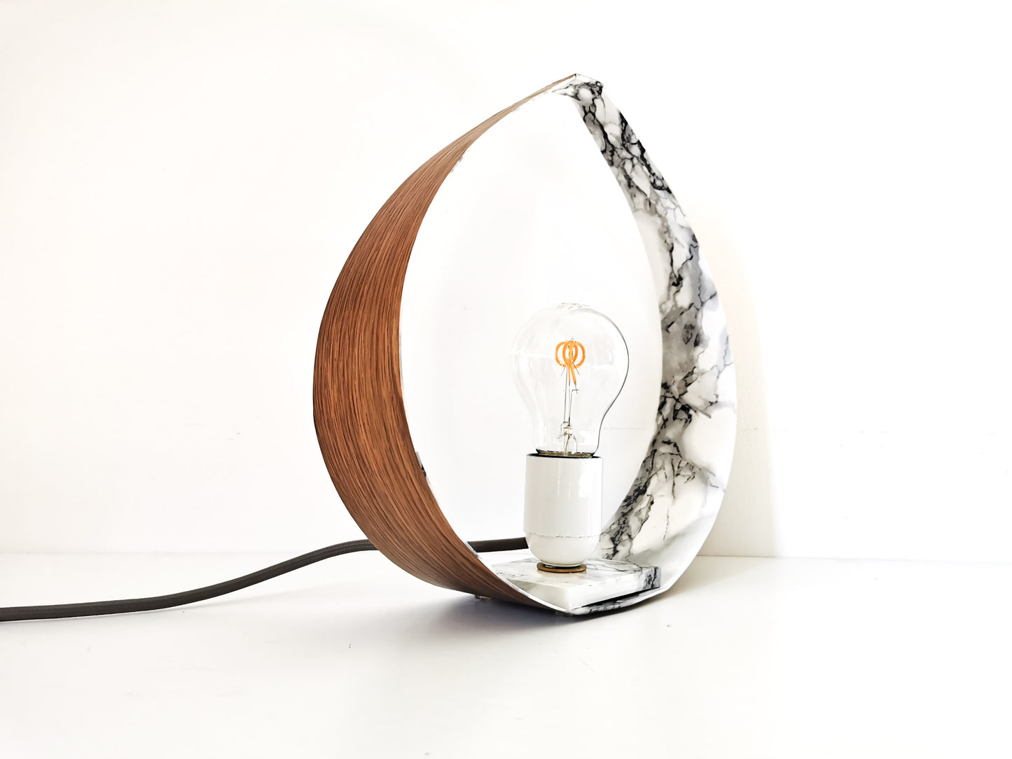 Une Lampe de Chevet à Poser en forme de goutte d'eau et de couleur marbre.