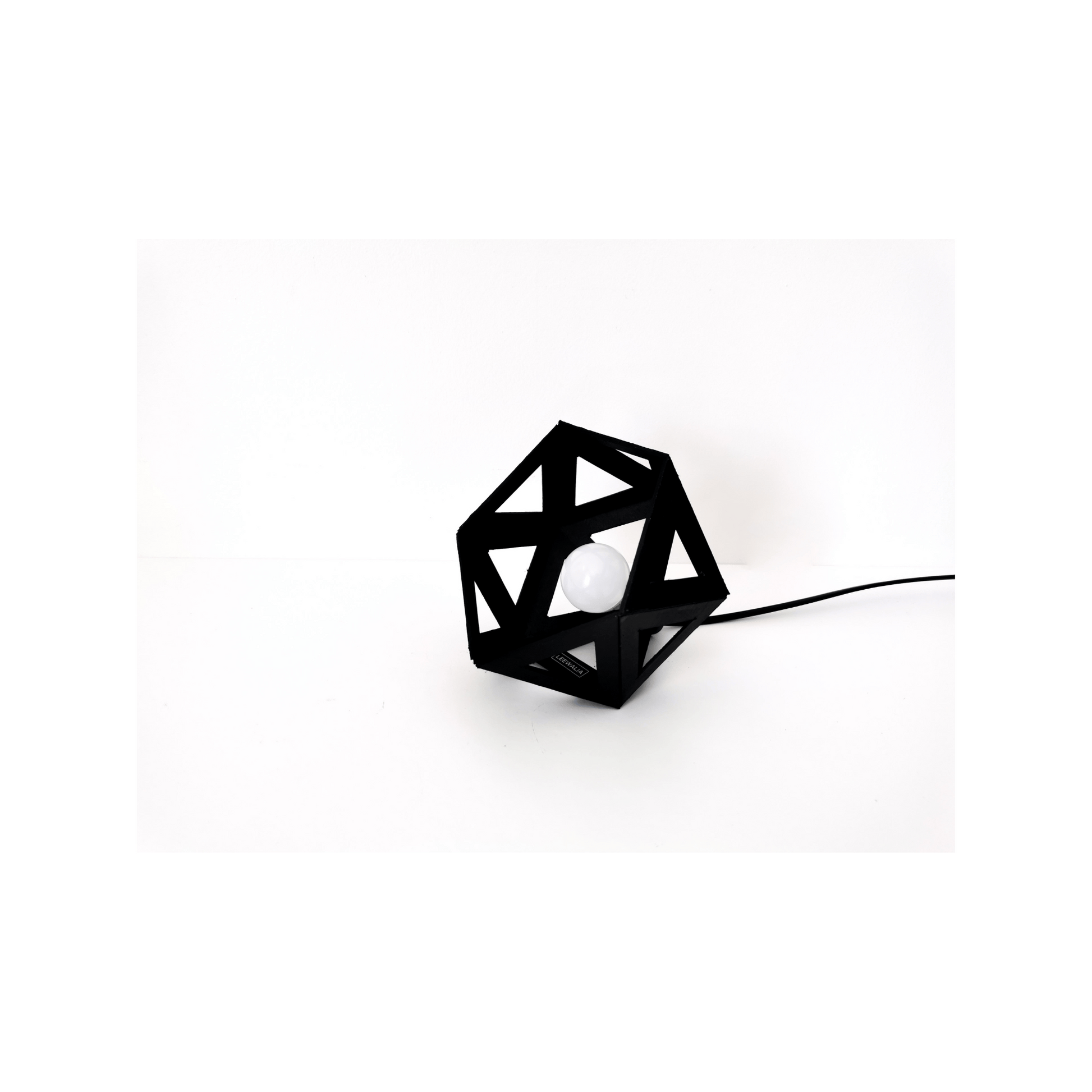 une lampe noir à poser de forme géométrique