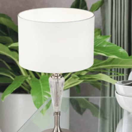 une lampe de chevet simple et intemporel avec une base en verre et abat jour blanc