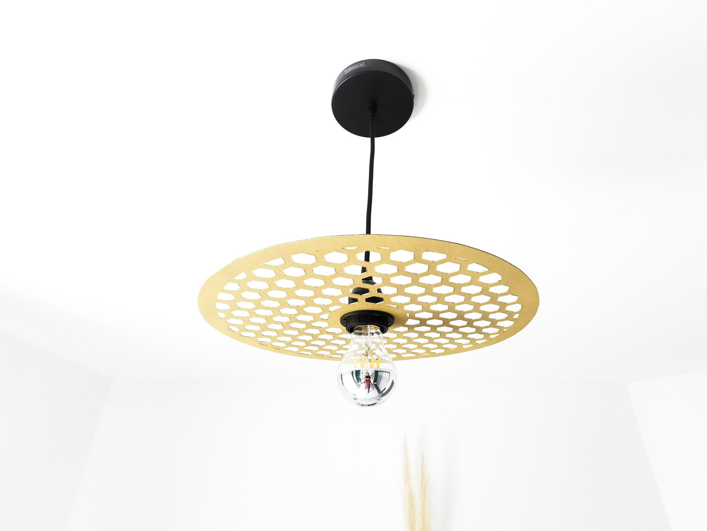 une lampe suspendue couleur dorée et formes géométriques